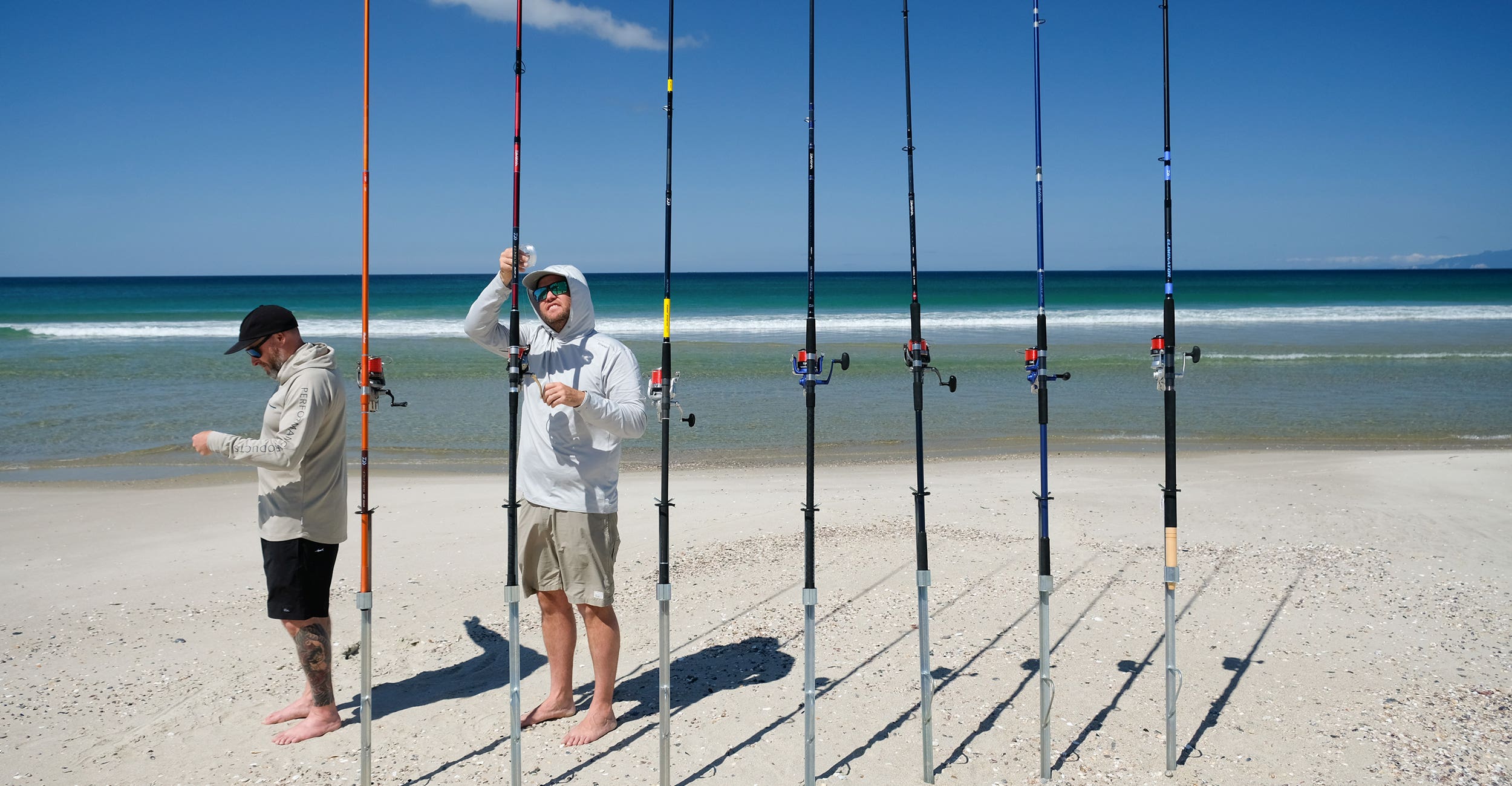 People rigging surfacting rods at the beach